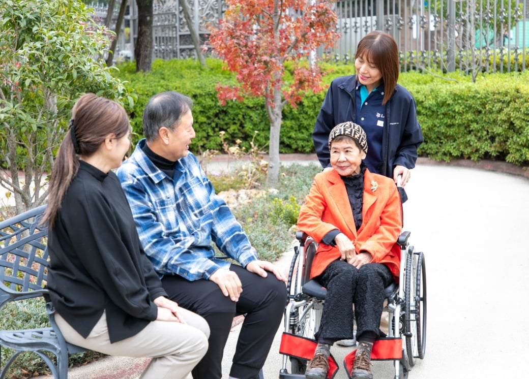 遊歩道で談笑中のご利用者様・ご家族様・スタッフ