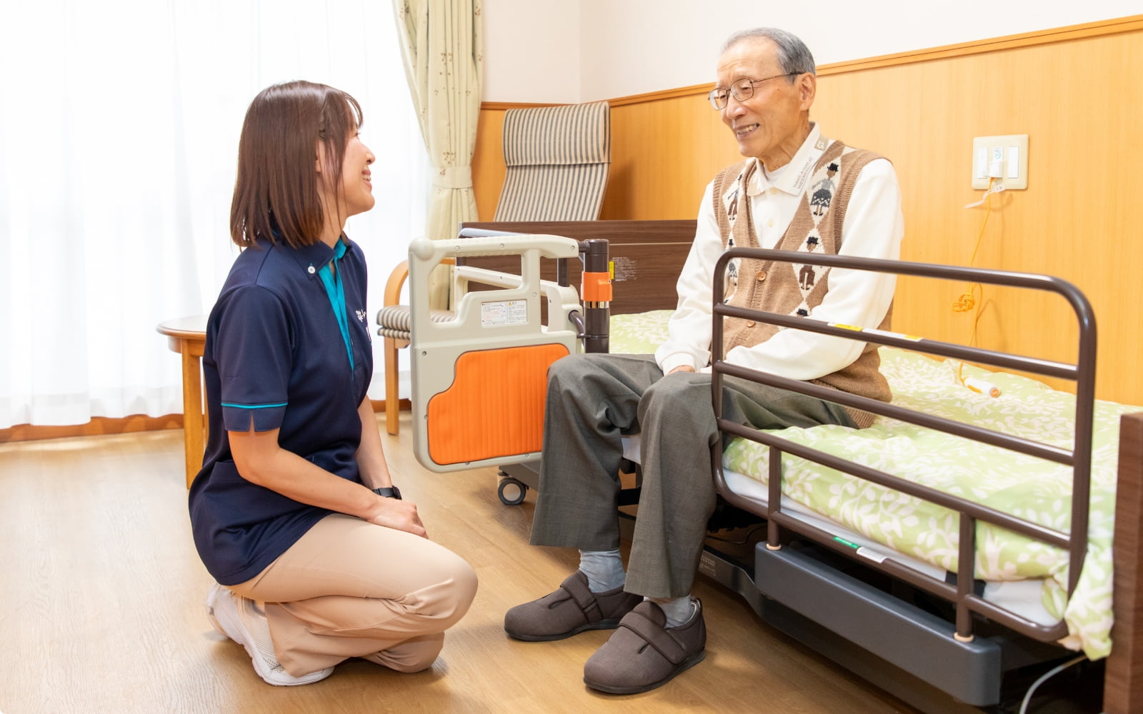 居室で会話するご利用者様とスタッフ