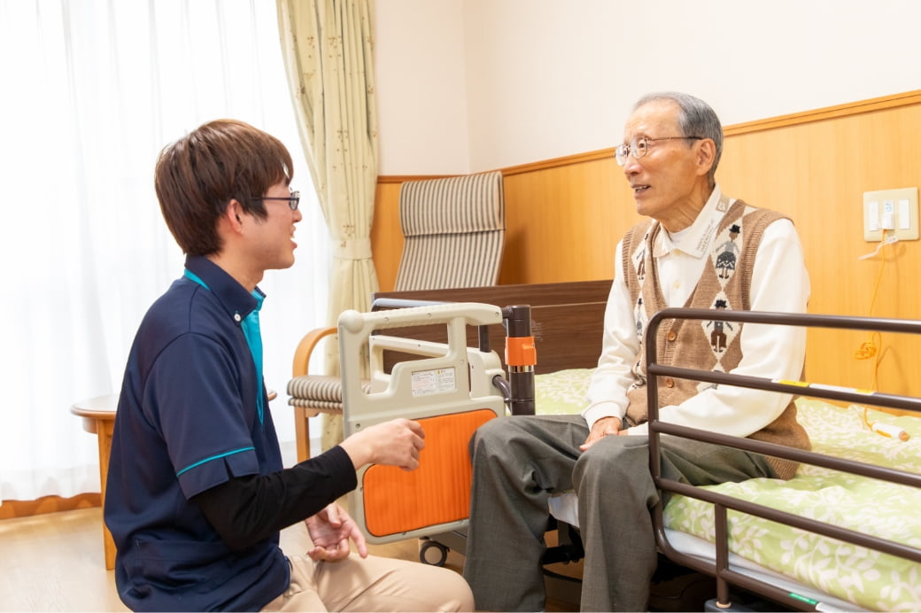 居室で会話中のご利用者様とスタッフ